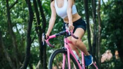 Full length of woman riding bicycle on road